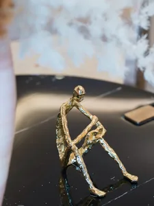 A minimalist figurine crafted from brass material.
