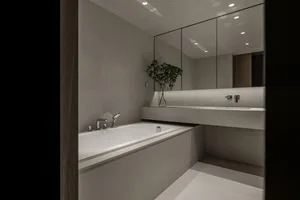 A minimalist modern bathroom with concrete walls and white fixtures.