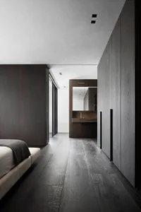 Modern bedroom suite with gray wood flooring and a concrete countertop, featuring a white bed.
