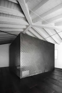 A geometric black box with a metal grid design in a modern interior setting
