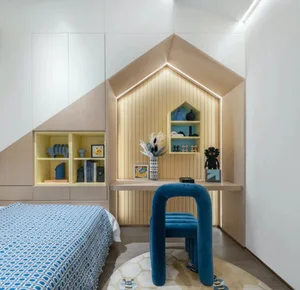 Modern, minimalist bedroom featuring blue accents, a blue upholstered chair, and a blue patterned bedspread.