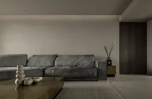 Modern minimalist living room featuring a gray sofa and sleek coffee table.