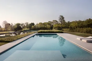 Modern pool with concrete walls and an outdoor setting surrounded by greenery.