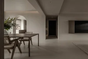 Modern residential interior featuring minimalist design, wooden furniture, and concrete flooring.