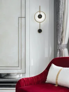 A luxurious red velvet chaise lounge with a metal armrest and a marble side table.