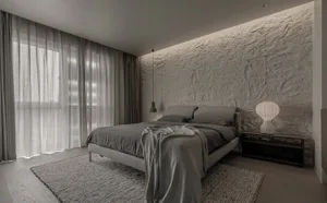 Minimalist bedroom featuring a bed with a fabric texture on a grey background.