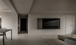 A modern minimalist living room with a concrete floor, dark wood furniture, and a large TV mounted on the wall.