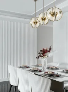 Modern dining room with white decor, including tables, chairs, and hanging lights.