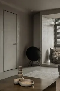 A modern living room with concrete walls and wooden furniture.
