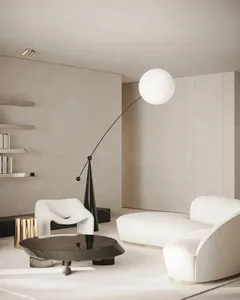 Contemporary living room with white and beige color palette, featuring a round coffee table, white armchair, and curved sofa,