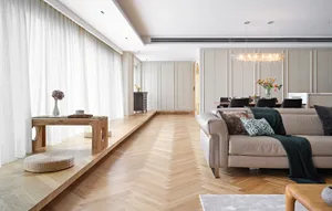 A spacious, contemporary living room with a wooden floor, modern furniture, and neutral color palette.