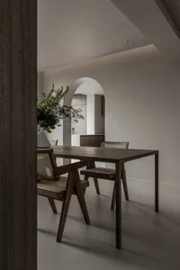 簡約風格的餐廳內擺放木質餐桌與餐椅，桌上擺放新鮮綠植花瓶。
