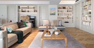 Modern minimalist living room with wood and fabric furniture and books on shelves.