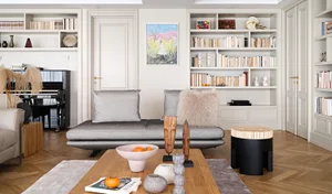 A modern living room with neutral-toned furniture, wooden floor, and bookshelves filled with books.