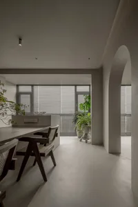 Minimalist residential dining area with concrete floor, wooden table, and chairs.