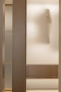 A modern closet interior with a frosted glass touch-screen door.