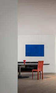 A modern living space featuring a wooden table and a red chair.
