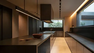 A modern, minimalist kitchen with concrete countertops and a large window.