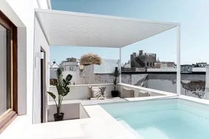 Modern minimalist rooftop deck featuring concrete and glass elements.