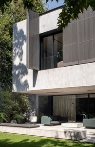 A modern front yard terrace featuring concrete structures and greenery.