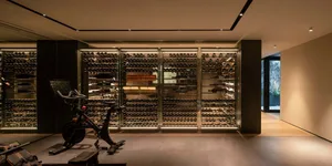 Modern gym interior with glass walls and concrete flooring, featuring a stationary bike.