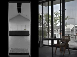 A modern interior design featuring a large glass window with a view of greenery.