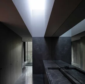 Modern, black-tiled bathroom with granite countertops and recessed lighting.