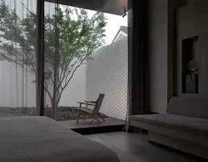 Living room with modern design, glass walls, wooden furniture, and brick elements.