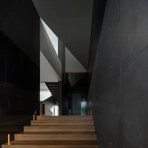 Modern interior design featuring wooden stairs and sleek, dark walls.