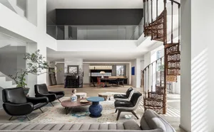 A modern living room with white painted floors, contemporary furniture, and minimalistic design elements.