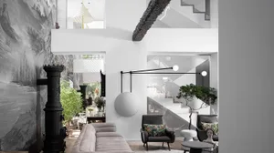 An industrial-style living room with concrete walls, wooden floors, and metal furniture.
