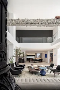 A modern residential interior featuring concrete, glass, and marble elements.