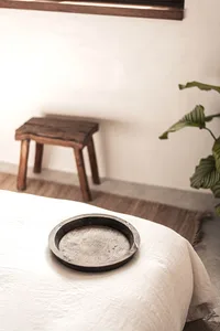 A minimalist bedroom with a wooden tray on a low bed.