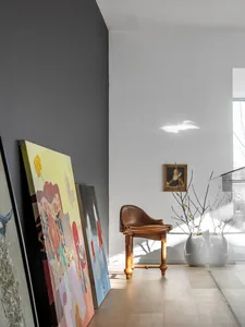 A modern interior design space featuring a wooden chair and colorful artwork.