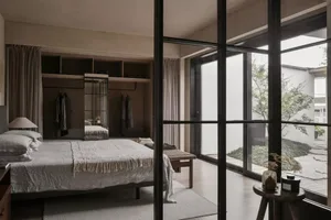 A modern bedroom featuring minimalist design elements with a focus on a light, airy aesthetic.