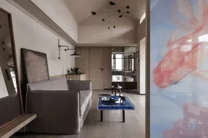 A modern living room with a grey sofa, coffee table, and abstract art on the walls.