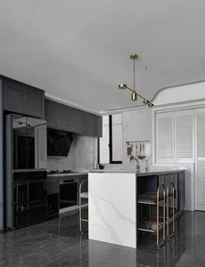 A modern minimalist residential kitchen with a white marble island and black cabinetry.