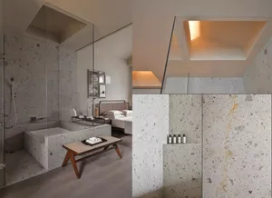 Modern bedroom with concrete walls and floor, featuring a double bed and minimalist decor.
