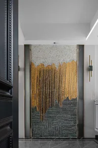 A modern interior design featuring a glass panel with intricate gold and black patterns.