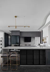 A modern kitchen featuring marble countertops and decorative lighting fixtures.