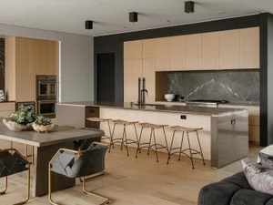 Modern residential kitchen featuring wooden cabinets and a marble backsplash.