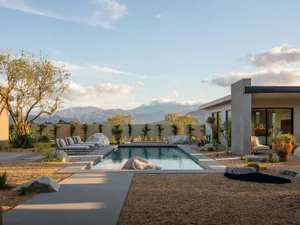 Modern minimalist residential exterior featuring a pool with terrazzo flooring.