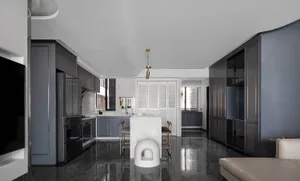Modern open-plan kitchen and living room with black marble countertops and black glass cabinets.