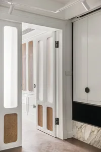 Interior shot of a modern closet with white painted walls, natural woven accents, and sliding doors.