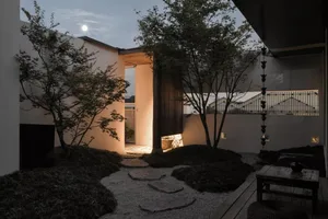 A modern architectural space featuring concrete pavement path leading through a courtyard.