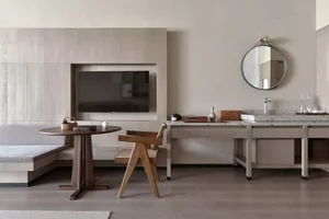 Modern residential interior with a combination of wooden furniture and cement flooring, featuring a seating area, round table