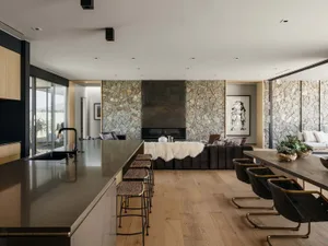 A modern industrial residential interior featuring stone, wood, and leather elements.