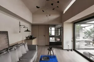 Modern living room featuring a minimalist design with wooden furniture and a blue rug.