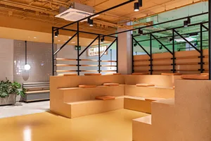 Modern industrial restaurant seating area with concrete, brick, and wooden elements
