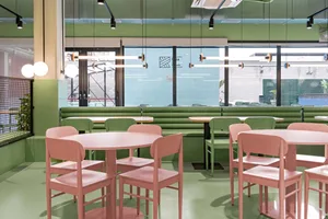 A modern cafe interior with colorful furniture and green walls